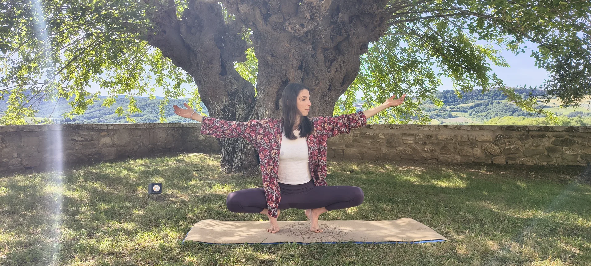 Pratica yoga sotto un albero nel Chianti